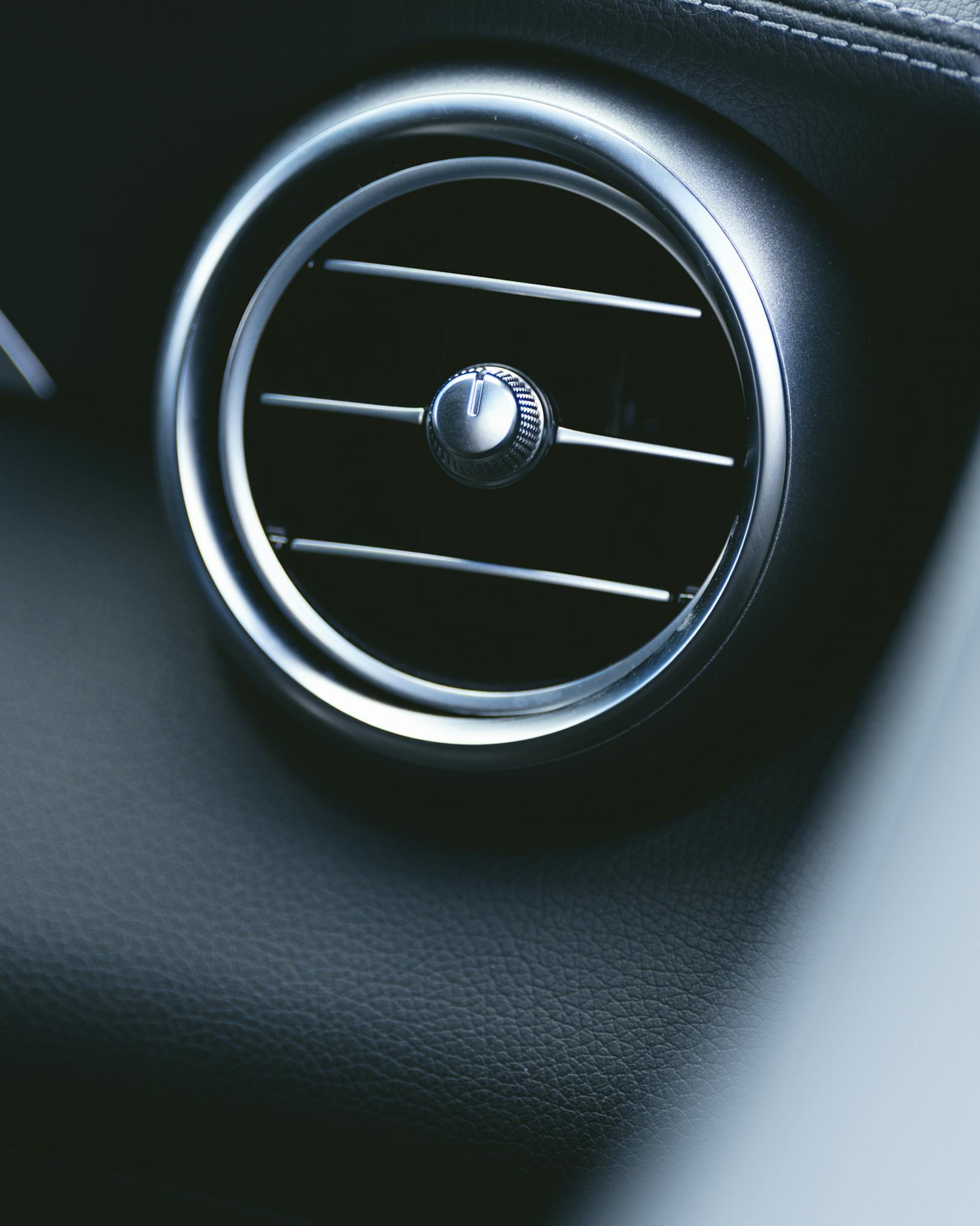 Rond ventilatierooster in een donker autodashboard